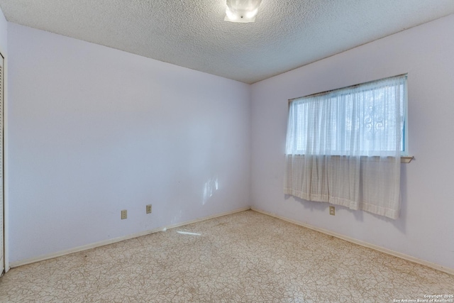 carpeted empty room with a textured ceiling