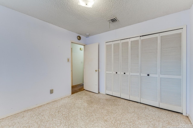 unfurnished bedroom featuring light colored carpet, a closet, and a textured ceiling