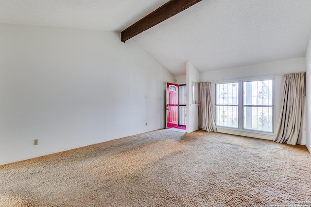 carpeted spare room featuring vaulted ceiling with beams and a textured ceiling