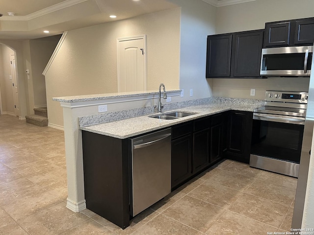 kitchen with light stone counters, kitchen peninsula, crown molding, appliances with stainless steel finishes, and sink