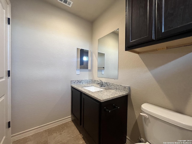 bathroom featuring tile patterned flooring, vanity, and toilet