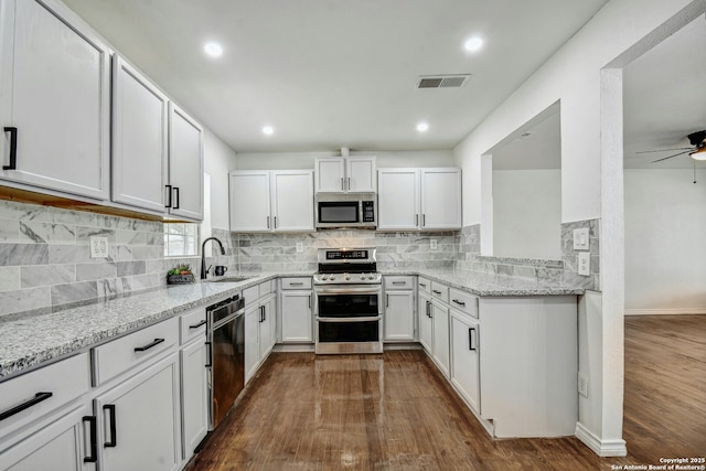 kitchen with white cabinetry, ceiling fan, light stone counters, and appliances with stainless steel finishes