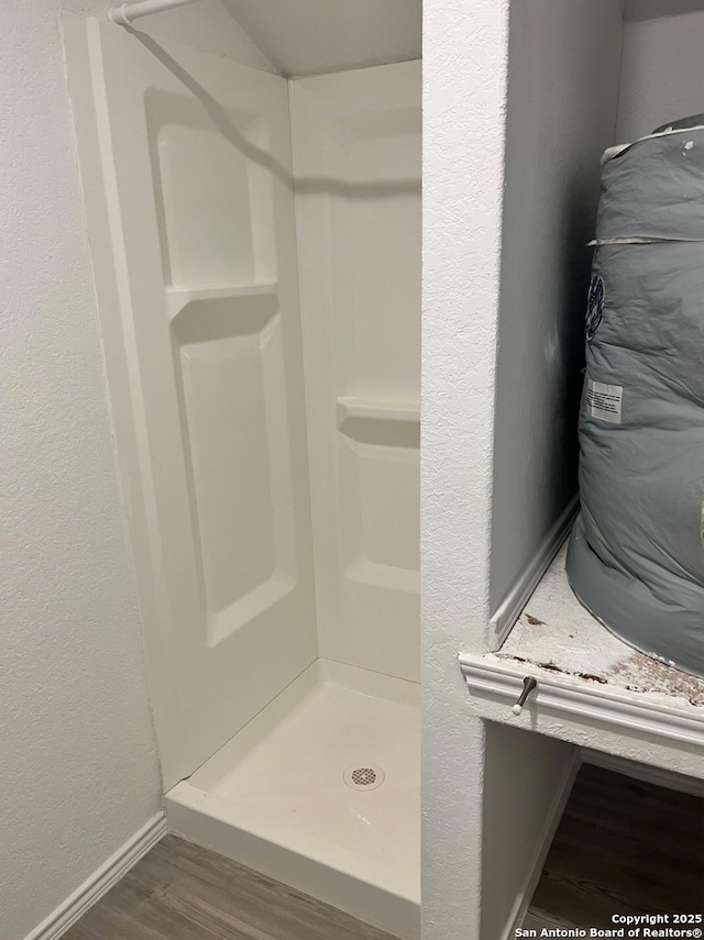 bathroom featuring a shower and hardwood / wood-style floors