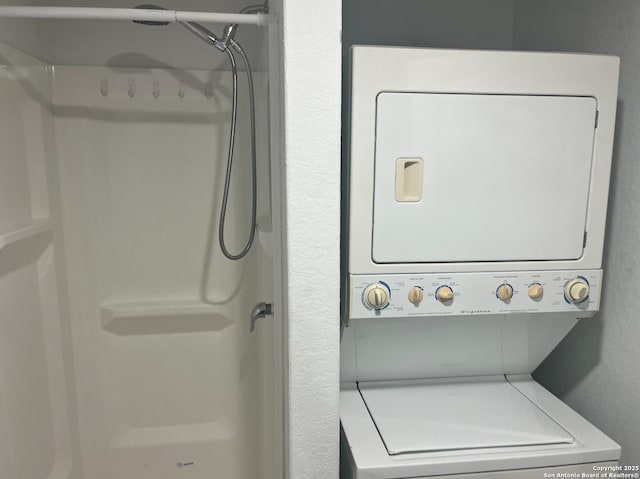 clothes washing area featuring stacked washer and clothes dryer