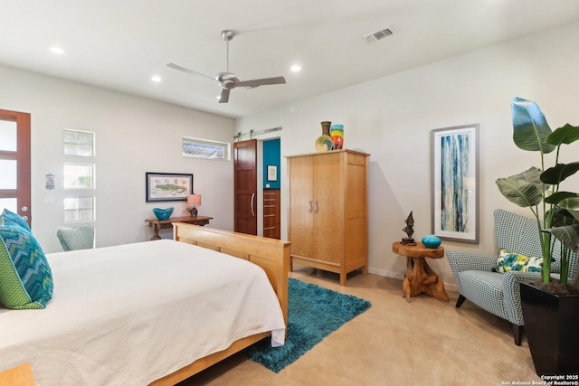 bedroom with ceiling fan and a barn door