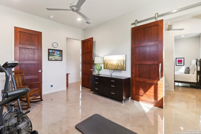 exercise area featuring ceiling fan and a barn door