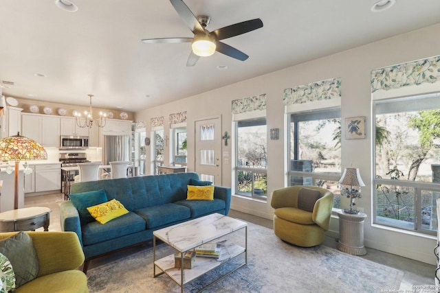 living room featuring ceiling fan with notable chandelier and a healthy amount of sunlight