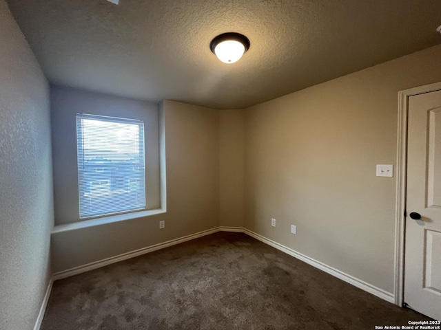 carpeted spare room with a textured ceiling