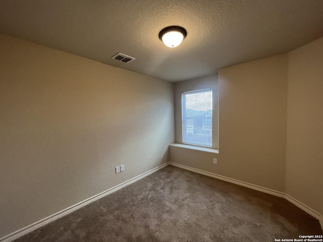 carpeted spare room featuring a textured ceiling