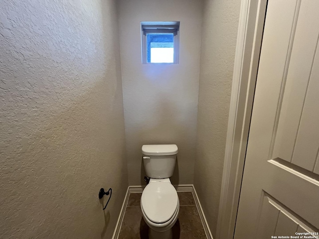 bathroom with toilet and tile patterned flooring