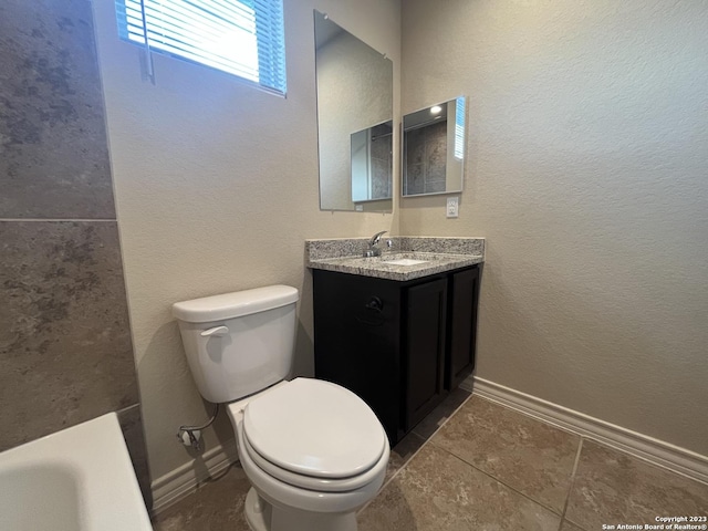 bathroom featuring toilet, tile patterned floors, vanity, and a washtub