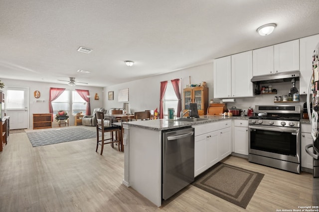 kitchen with white cabinetry, kitchen peninsula, and appliances with stainless steel finishes