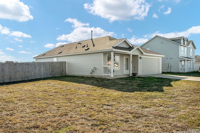 back of house featuring a garage and a yard