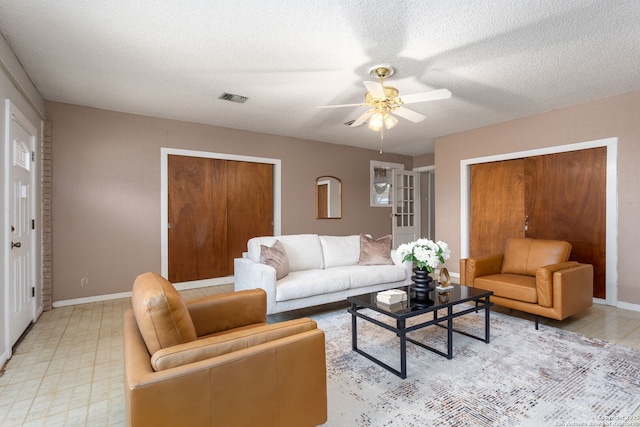 living room featuring a textured ceiling and ceiling fan