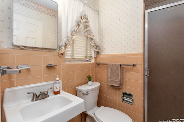 bathroom with tile walls, sink, and toilet