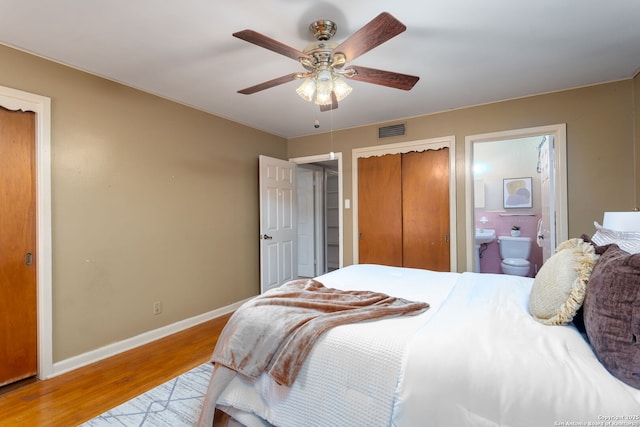 bedroom with ensuite bathroom, ceiling fan, and light hardwood / wood-style floors