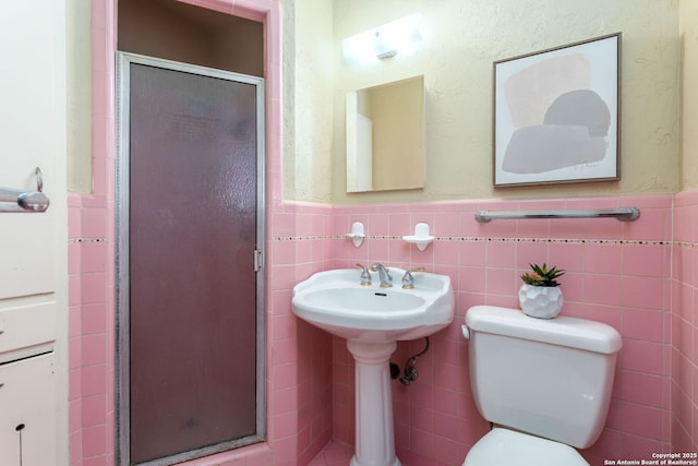 bathroom featuring toilet, tile walls, and walk in shower