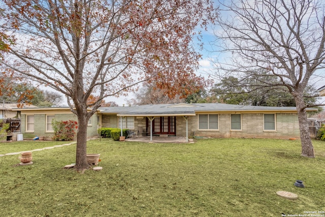 back of property featuring a lawn and a patio