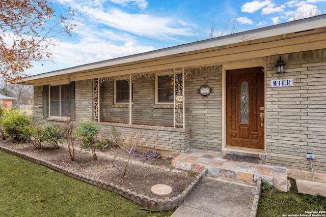 view of exterior entry featuring covered porch