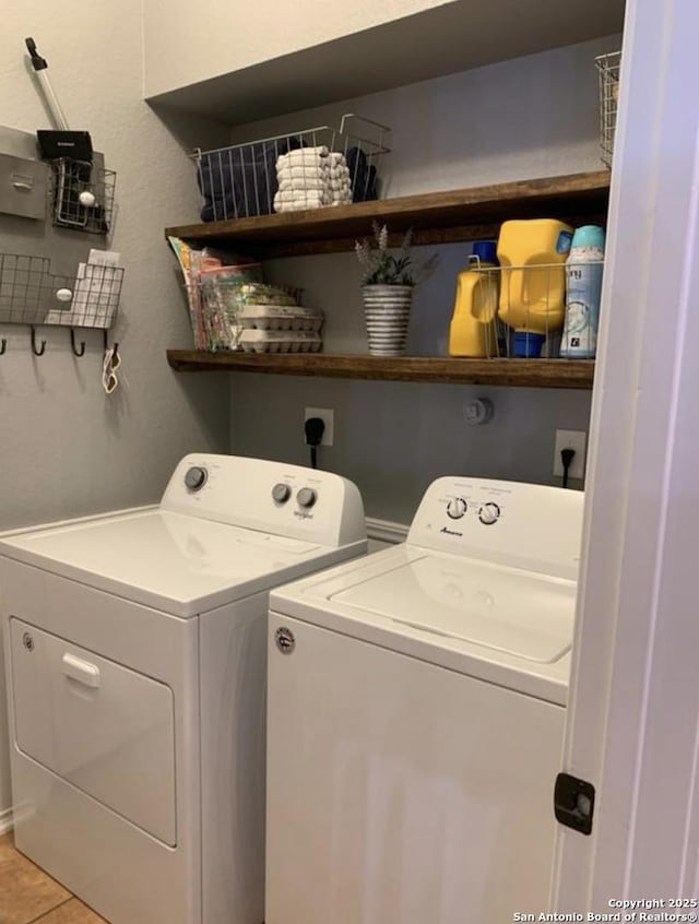 laundry room with light tile patterned floors and washer and clothes dryer