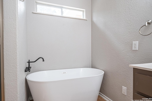 bathroom with vanity and a washtub