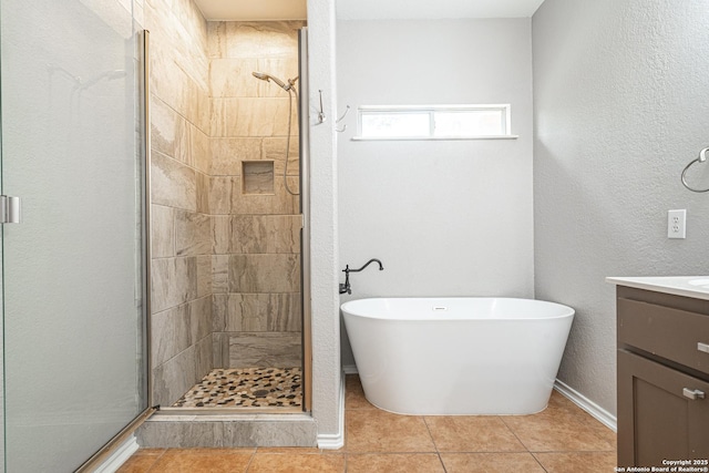 bathroom featuring tile patterned floors, vanity, and plus walk in shower