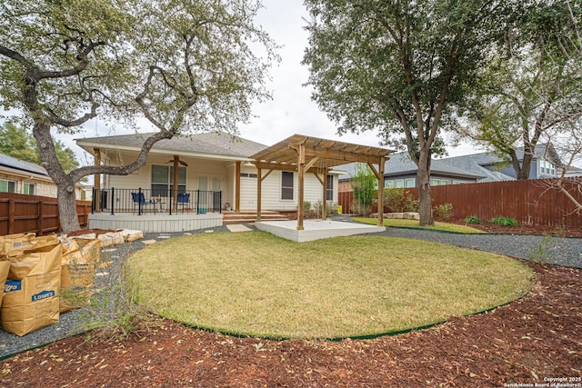 rear view of property featuring ceiling fan, a pergola, a patio, and a lawn