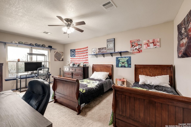 bedroom with a textured ceiling, ceiling fan, and light carpet