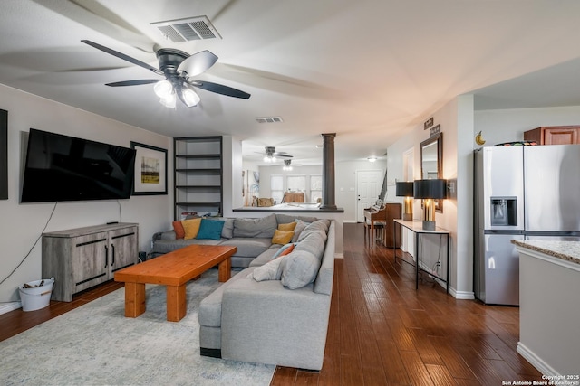 living room with ceiling fan, decorative columns, and dark hardwood / wood-style floors