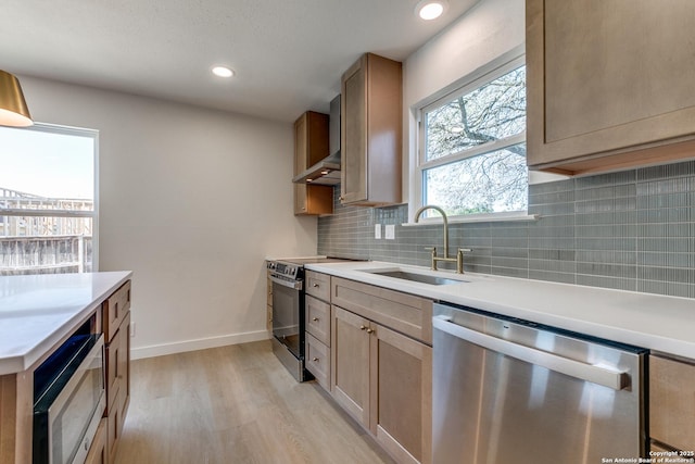 kitchen featuring sink, light wood-type flooring, tasteful backsplash, extractor fan, and appliances with stainless steel finishes