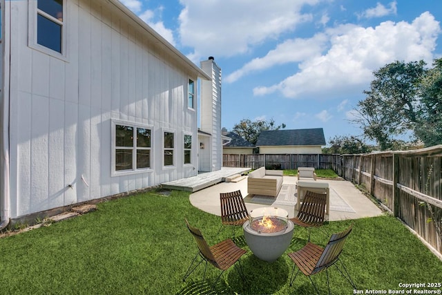 view of yard with an outdoor living space with a fire pit and a patio