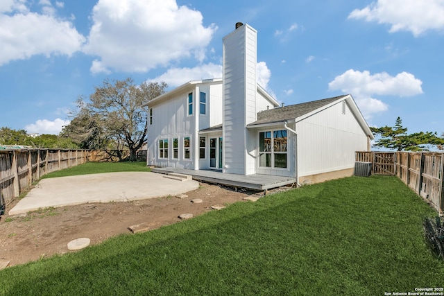 back of property with a patio area, a wooden deck, and a yard