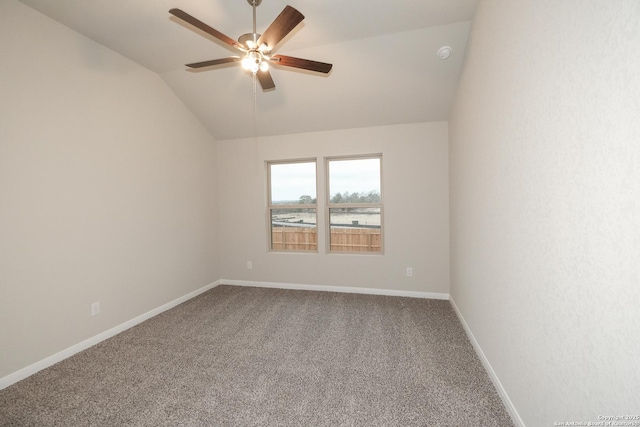 carpeted spare room featuring lofted ceiling, ceiling fan, and a water view