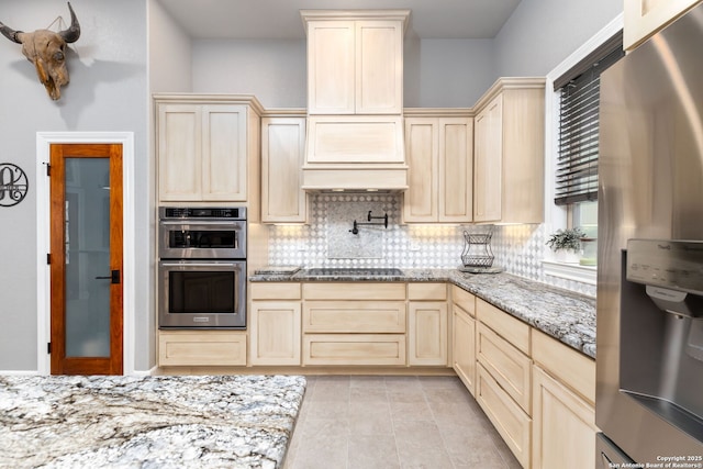 kitchen with stainless steel appliances, light tile patterned flooring, decorative backsplash, and light stone countertops