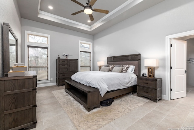 bedroom featuring a towering ceiling, ornamental molding, a raised ceiling, and ceiling fan