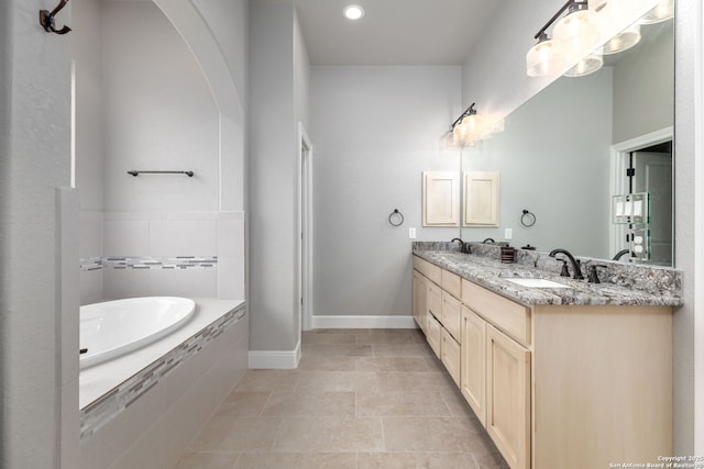 bathroom with tiled tub, tile patterned floors, and vanity