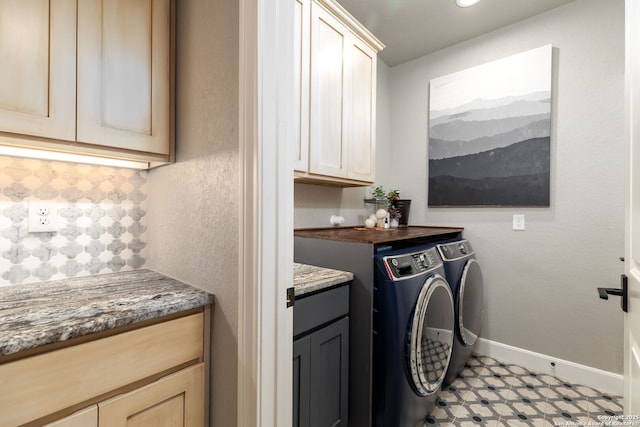 clothes washing area featuring cabinets and washer and clothes dryer