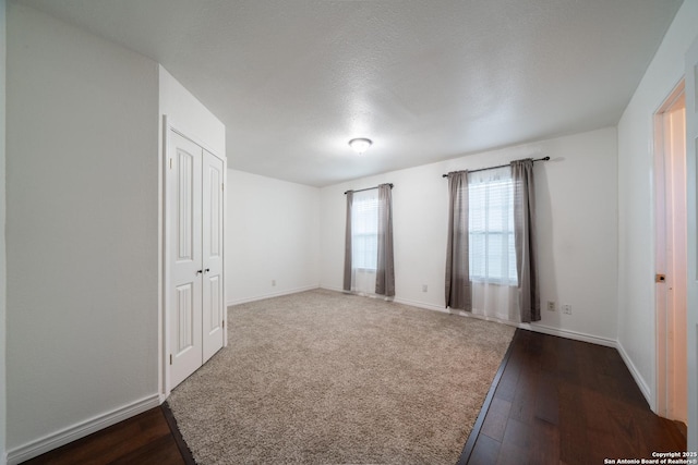 unfurnished room featuring a textured ceiling and dark hardwood / wood-style floors