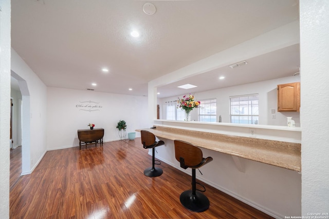 kitchen featuring built in desk, dark hardwood / wood-style flooring, and light brown cabinets