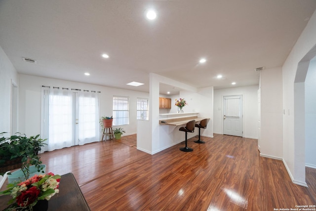 kitchen with a breakfast bar, dark hardwood / wood-style flooring, french doors, and kitchen peninsula