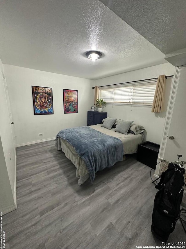 bedroom with a textured ceiling and hardwood / wood-style flooring