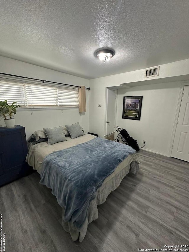 bedroom featuring a textured ceiling and dark wood-type flooring