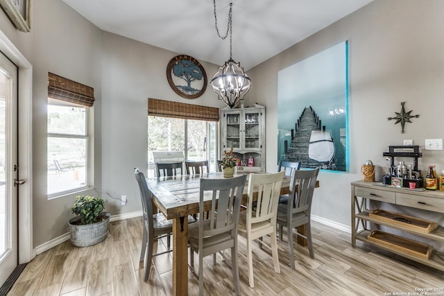 dining area featuring an inviting chandelier, plenty of natural light, and light hardwood / wood-style flooring