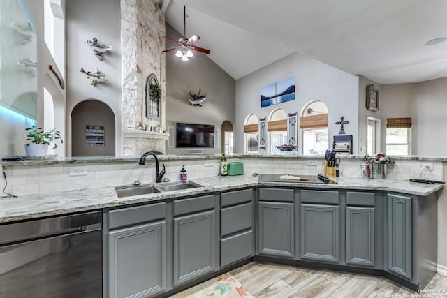 kitchen featuring light stone counters, black appliances, tasteful backsplash, gray cabinetry, and sink