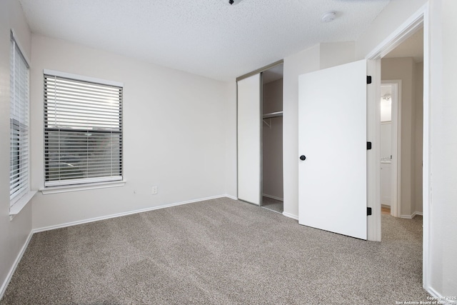 unfurnished bedroom with a textured ceiling, a closet, and carpet