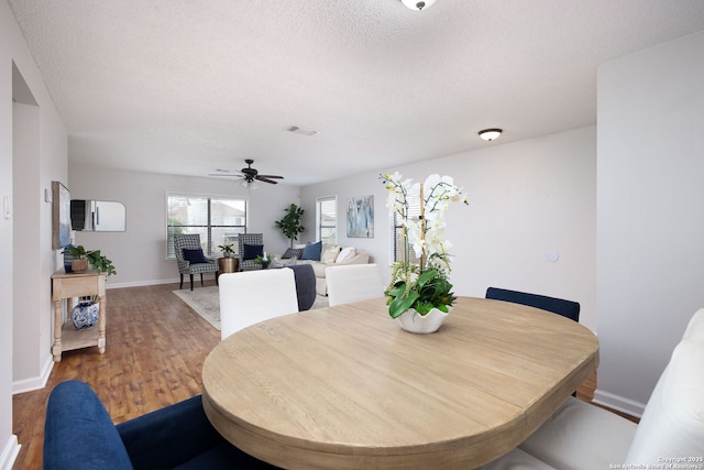 dining room featuring ceiling fan, a textured ceiling, and hardwood / wood-style flooring