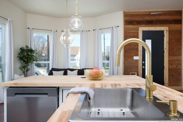 kitchen featuring sink, butcher block counters, dishwasher, and hanging light fixtures