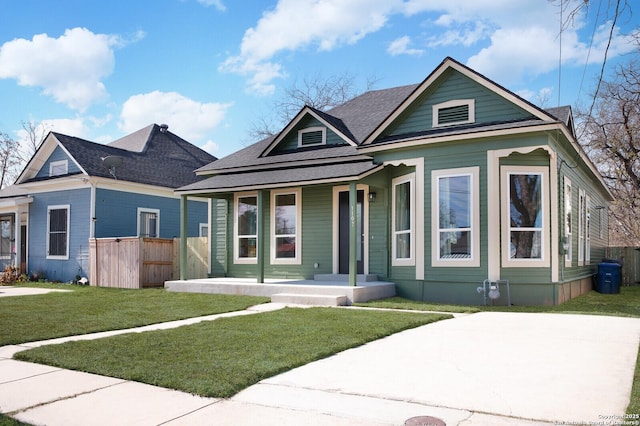 bungalow-style house with a front yard and covered porch