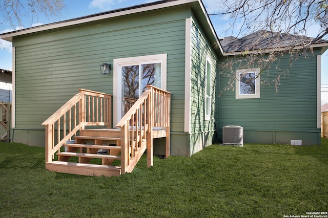 rear view of property featuring a yard and cooling unit