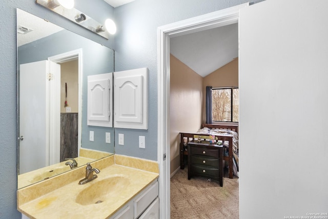 bathroom with lofted ceiling and vanity